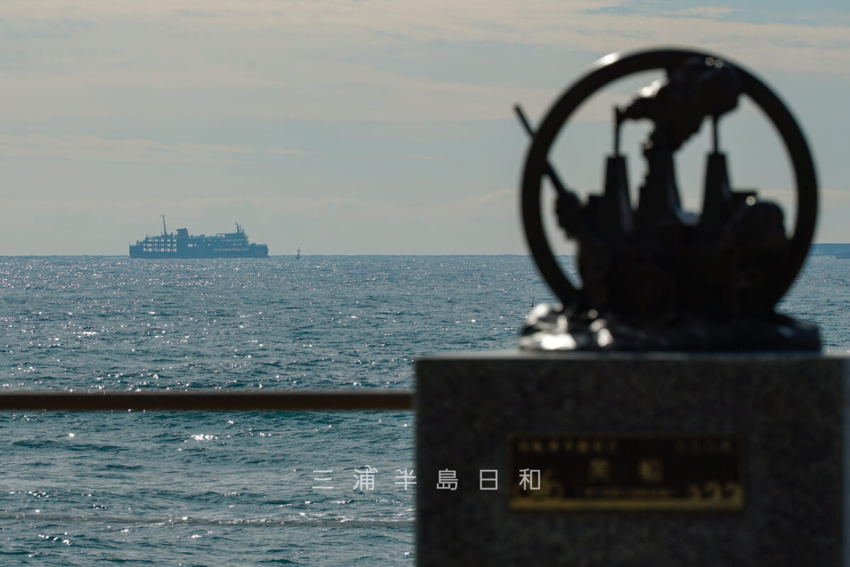 たたら浜・サイクリングマイルストーン「黒船」と黒船ラッピングの東京湾フェリーの遠望（撮影日：2024.01.23）