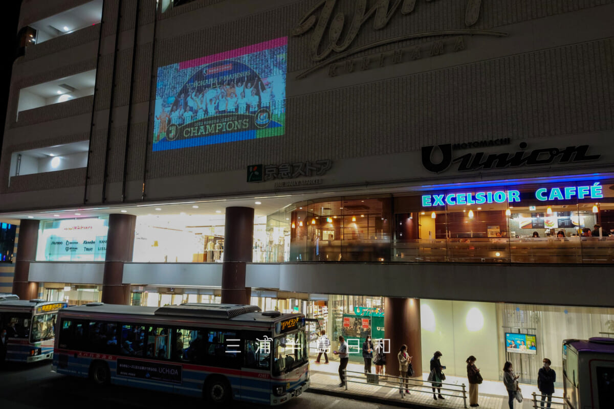 京急久里浜駅・横浜F・マリノスのJ1優勝記念ムービーの駅ビルのウィング久里浜壁面に投影[アップ]（撮影日：2022.11.11）