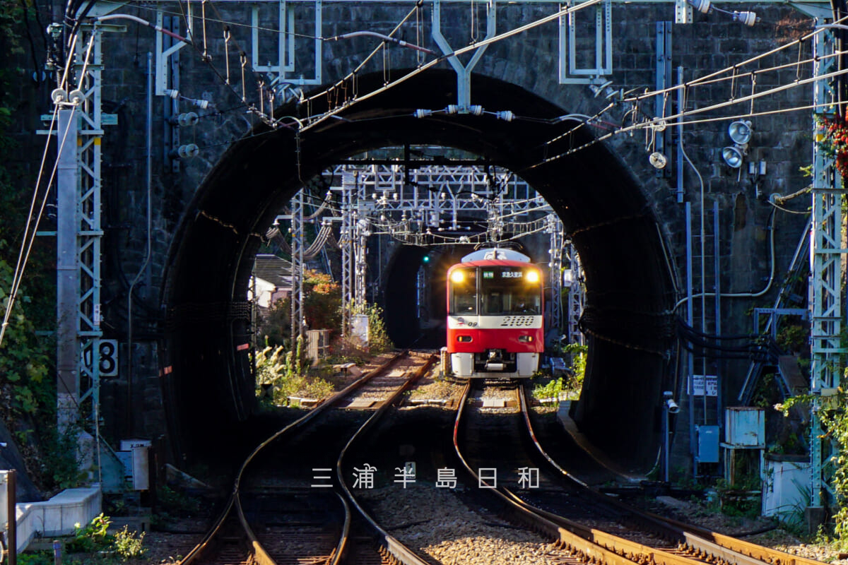逸見駅・上りホームより安針塚駅方面のトンネルからやって来る2100形電車を望む(撮影日:2021.11.25)