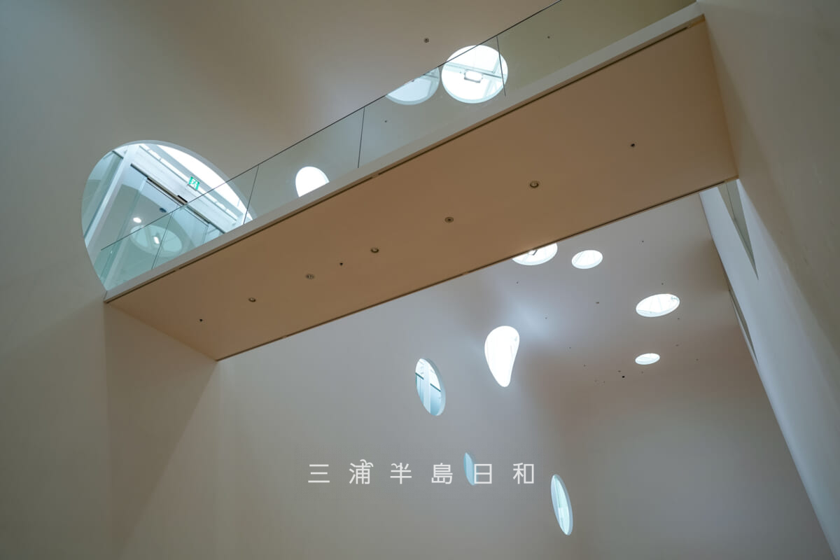 横須賀美術館・ランダムな丸窓が特徴的なエントランスホール前の吹き抜けを見上げる（撮影日：2024.07.01）